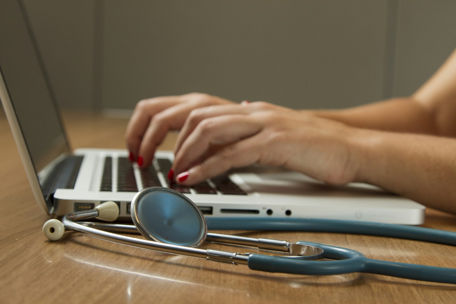 Laptop and stethoscope on a desk